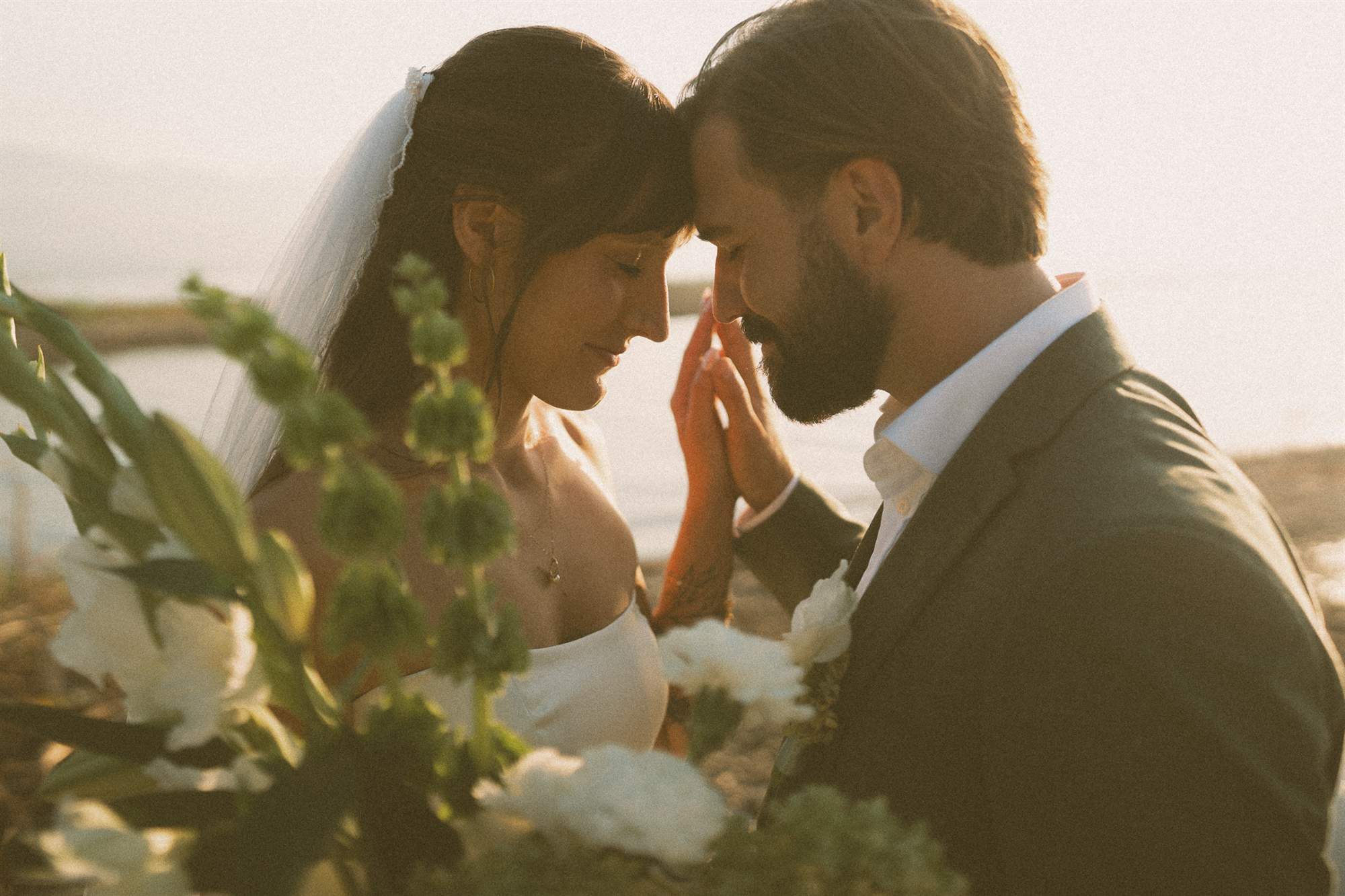 Bride and groom foreheads together at golden hour beside Okanagan Lake, a Kelowna wedding